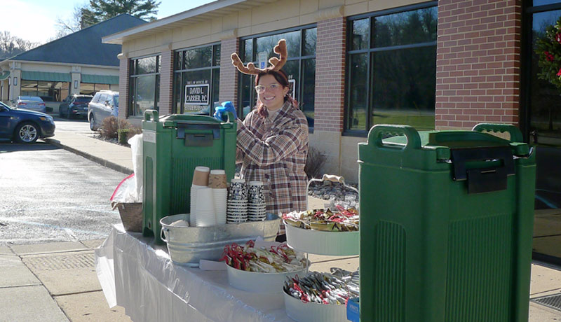 team member pouring hot chocolate during the december 17 event