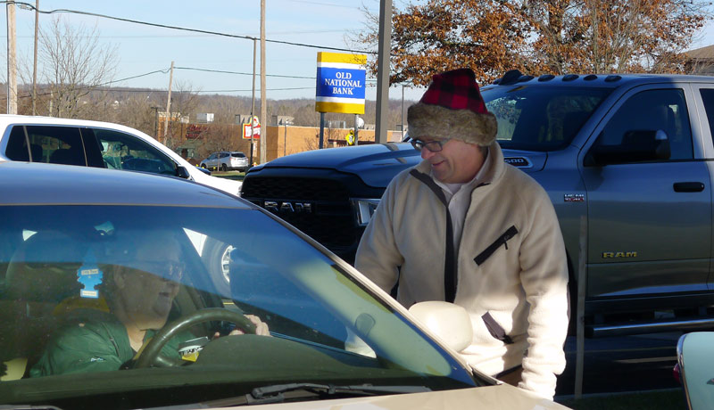 greg van deusen hands out treats during the cookie and cocoa drive-by