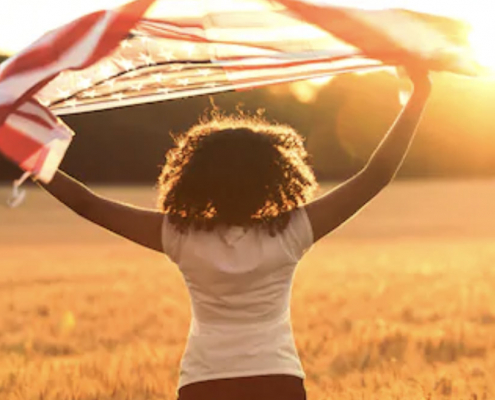 girl with american flag in a field